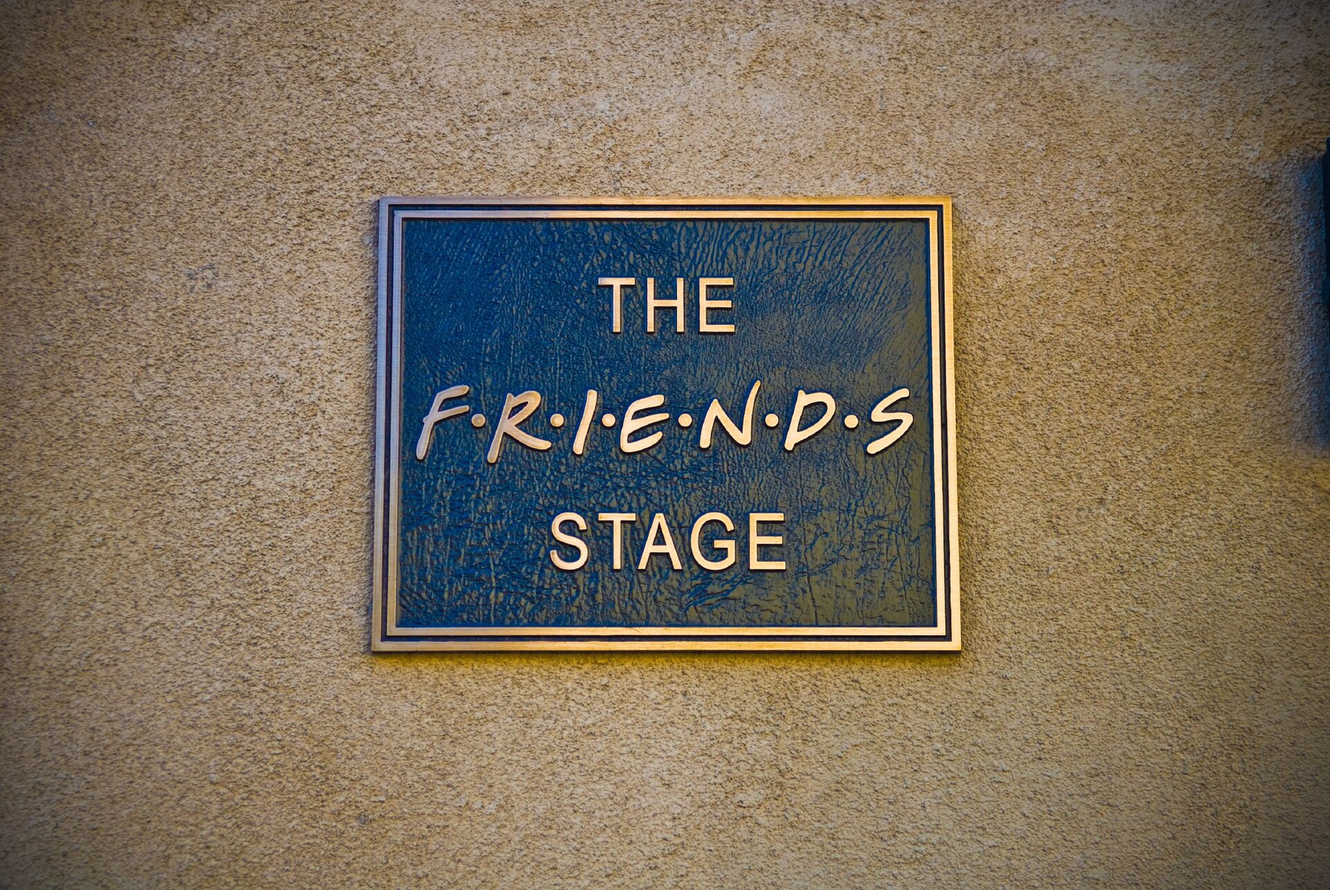 Plaque en bronze The Friends Stage fixée sur le mur crépi d’un plateau de studio